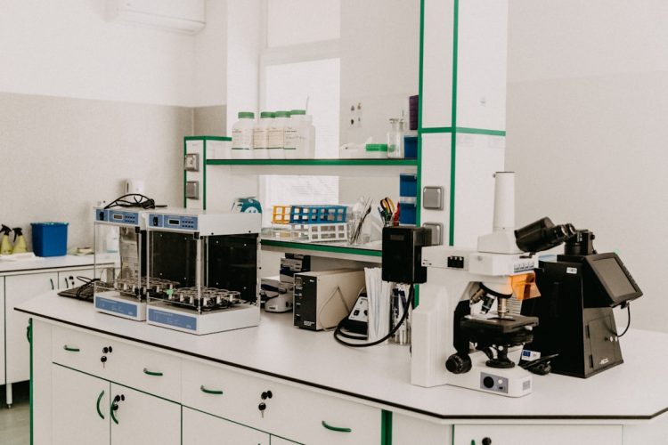 A clean laboratory workspace with scientific equipment including a microscope and laboratory instruments